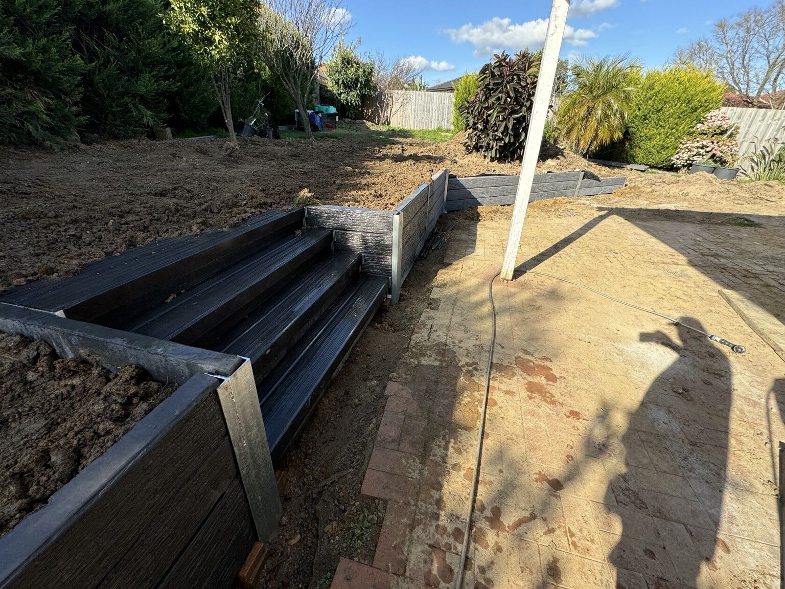 A concrete sleeper staircase built into a sleeper retaining wall on galvanised posts, Berwick, before landscaping.