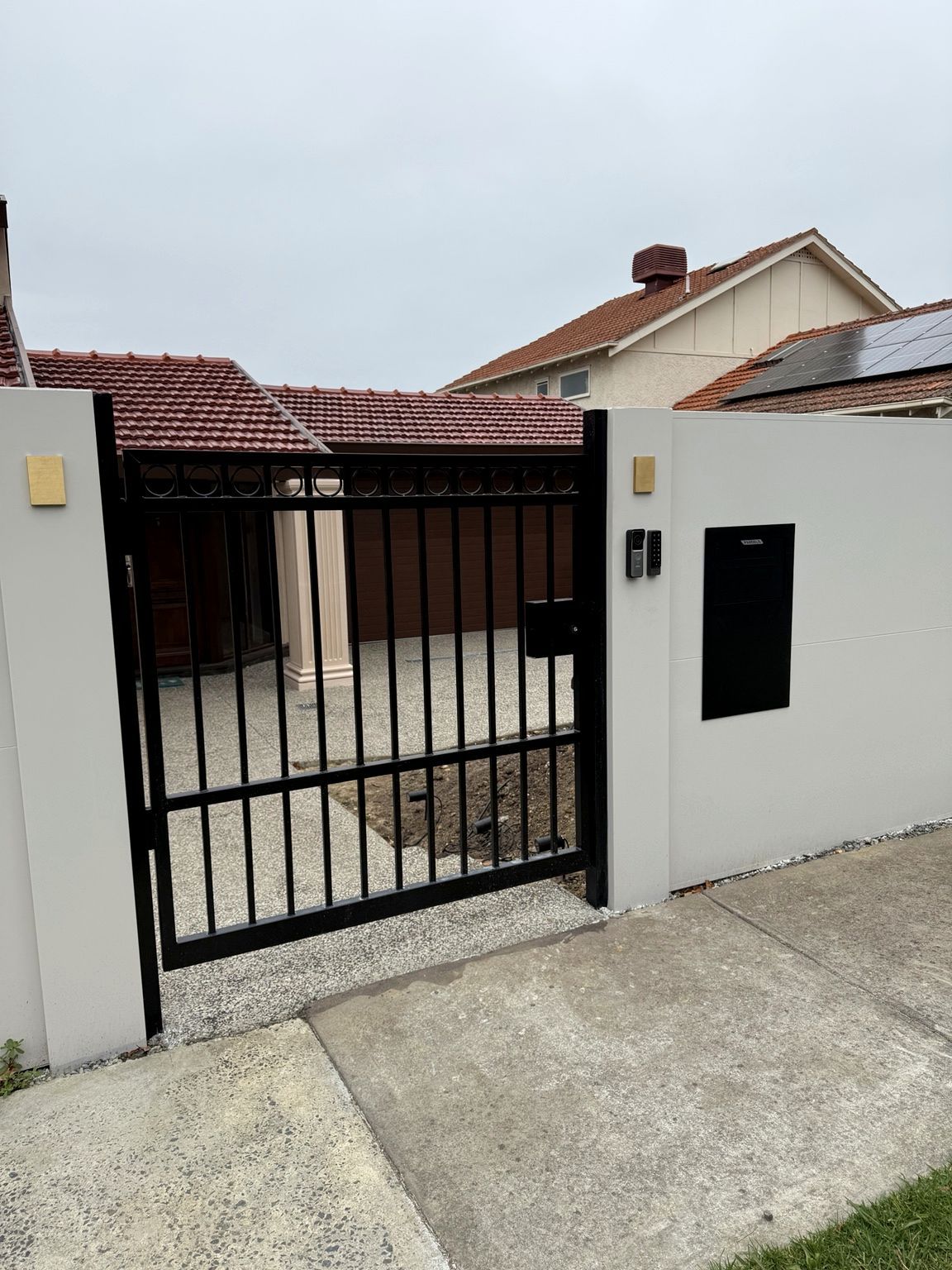 Pedestrian gate between EstateWall piers at Camberwell, with a video intercom, keypad and a black parcel box set into the wall.